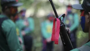 red ribbon is tied to a firearm of a New People's Army guerrilla in the Philippines