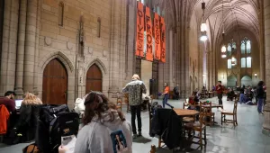 Students at left watch as student activists take positions in the Cathedral of Learning