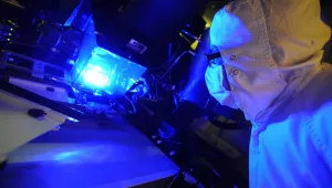 an operator inspects a photolithography tool used to manufacture these solar cells. 