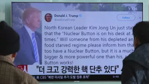People watch a TV news program showing the tweet of U.S. President Donald Trump while reporting North Korea's nuclear issue