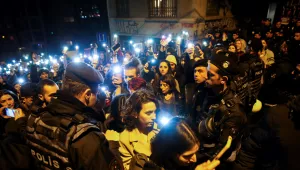 Protesters walk past a police security line 