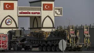 A Turkish forces truck transporting armored personnel carriers, crosses the border with Syria 