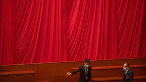 A staff member gestures to a delegate during a session of China's National People's Congress (NPC) at the Great Hall of the People in Beijing, Friday, March 10, 2023.