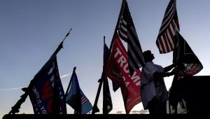 Nikki Fuller, 56, sets up flags on her truck near the Mar-a-Lago estate of President-elect Donald Trump, Monday, Nov. 11, 2024, in Palm Beach, Fla. (AP Photo/Julia Demaree Nikhinson)