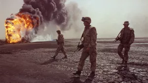 In this March 7, 1991 file photo, a U.S. Marine patrol walks across the charred oil landscape near a burning well during perimeter security patrol near Kuwait City.