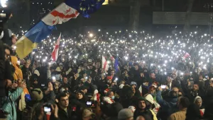Demonstrators stand in front of police during a rally