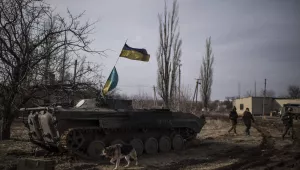 A stray dog runs past a Ukrainian military vehicle near Debaltseve, eastern Ukraine, Sunday, Feb. 8, 2015. The government-held town of Debaltseve, a key railway junction, has been the epicenter of recent battles between Russian-backed separatists and Ukrainian government troops. For two weeks, the town has been pounded by intense shelling that knocked out power, heat and running water in the dead of winter.