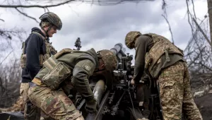 Ukrainian servicemen of Khartia brigade loading shell into M101 Howitzer before firing towards Russian positions in Kharkiv region, Ukraine, Wednesday, March 12, 2025. (AP Photo/Alex Babenko)