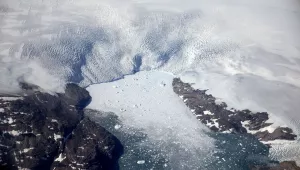 a glacier calves icebergs into a fjord off the Greenland ice sheet