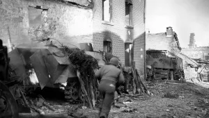 An American soldier runs past a burning German half-track in the recaptured town of La Gleize, Belgium, in 1944 during the Battle of the Bulge in World War II.