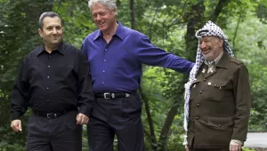 President Bill Clinton, center, accompanied by Israeli Prime Minister Ehud Barak, left, and Palestinian leader Yasser Arafat, right, walk on the grounds of Camp David, Md., on July 11, 2000, during a Mideast summit.
