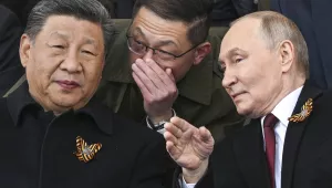 Russian President Vladimir Putin, right, and Chinese President Xi Jinping, left, talk as they watch the Victory Day military parade in Moscow, Russia, Friday, May 9, 2025.