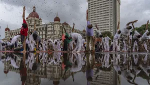 People perform Yoga to mark International Day of Yoga in front of Taj Mahal Palace hotel in Mumbai, India, Tuesday, June 21, 2022. Yoga enthusiasts across the world Tuesday took part in mass yoga events to mark Yoga Day. (AP Photo/Rafiq Maqbool)