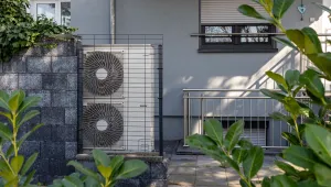 Air source heat pumps installed on the garden front of a modern house.
