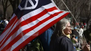 Peace activist Marilyn Cornell, of Strongsville, Ohio, holds an American flag with a peace sign on it during an anti-war protest in Washington, on Saturday, March 20, 2010. 