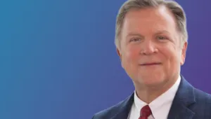 Headshot of Pat Wood against a blue gradient background.