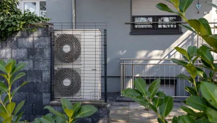 Air source heat pumps installed on the garden front of a modern house.