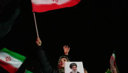 A woman waves an Iranian flag and holds a picture of the late Iranian Supreme Leader Ayatollah Ali Khamenei during a pro-government gathering in a square in western Tehran, Iran, Wednesday, March 25, 2026. (AP Photo/Vahid Salemi)