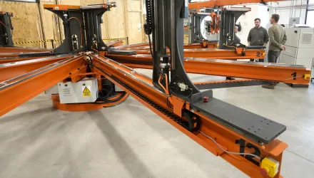 People stand near a magnet insulation wrapping machine at Commonwealth Fusion Systems, in Devens, Mass., Wednesday, Oct. 11, 2023.