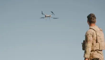 A soldier looks at a drone.