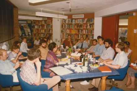 A group of people sitting around a conference table in a library.