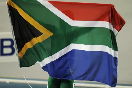 South Africa's Caster Semenya celebrates winning, holding a flag