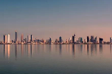 Kuwait City skyline over water at sunset