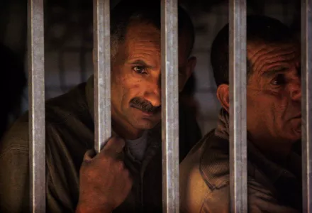 Palestinian workers wait to cross a checkpoint to work in Israel at the separation barrier in the West Bank town of Bethlehem early Sunday, June 21, 2009.