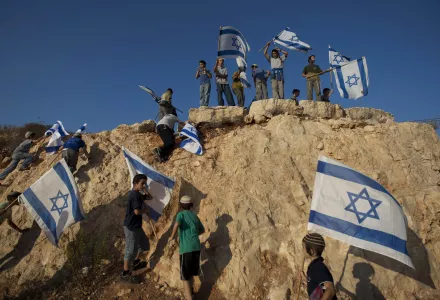 Israeli settler youths wave Israeli flags at the start of a protest march against Palestinian statehood, from the West Bank Jewish settlement of Itamar near the Palestinian town of Nablus, Tuesday, Sept. 20, 2011.