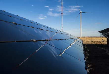 A small PV array used as part of Energy Systems Integration research ongoing at the National Wind Technology Center, 29 October 2019.  A wind turbine stands in the distance.