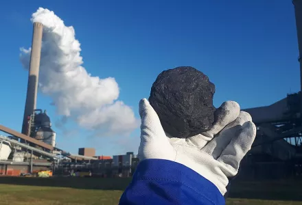  Worker holding up a piece of coal in front of a coal-fired power plant in the Netherlands, 12 December 2019.