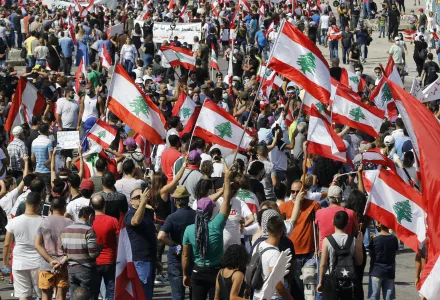 Anti-government protesters hold Lebanese national flags during a protest in downtown Beirut, Lebanon. 