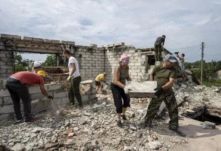 Volunteers clear rubble on the second floor of Zhanna and Serhiy Dynaeva's house which was destroyed by Russian bombardment, in a residential area, in the village of Novoselivka, near Chernihiv, Ukraine, Saturday, Aug. 13, 2022