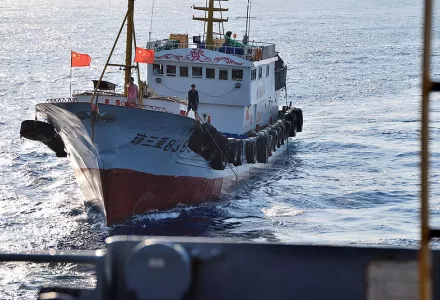A crewmember on a Chinese trawler uses a grapple hook in an apparent attempt to snag the towed acoustic array of the military Sealift Command ocean surveillance ship USNS Impeccable, 8 March 2009. Impeccable was conducting survey operations in the exclusive economic zone of China 75 miles south of Hainan Island when it was harassed by 5 Chinese vessels.