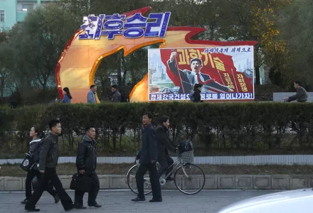 In this Saturday, Oct. 27, 2018 photo, people walk past a propaganda banner that reads "Final victory! With science and technology we build our economic power" in Pyongyang, North Korea.