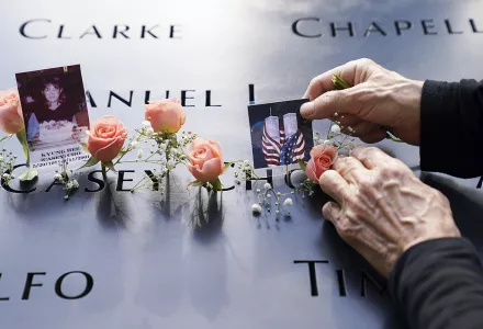 Mourners place flowers and pictures in the name cut-out of Kyung Hee (Casey) Cho at the National September 11 Memorial and Museum, Friday, Sept. 11, 2020, in New York. 