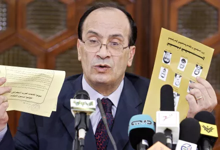 Tunisian Interior Minister Hedi Mehnni, holding the Popular Unity Party's candidates list, right, and the Progressive Democratic Party's list, both yellow, answers reporters about a possible confusion between the lists during a press conference in Tunis, Monday Oct. 25, 2004. Tunisian President Zine El Abidine Ben Ali i won re-election by an overwhelming margin in balloting marred by a boycott by an opposition party which called the vote a sham. 