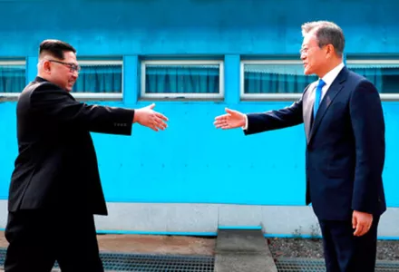 North Korean leader Kim Jong Un, left, prepares to shake hands with South Korean President Moon Jae-in over the military demarcation line at the border village of Panmunjom in the Demilitarized Zone on April 27, 2018.