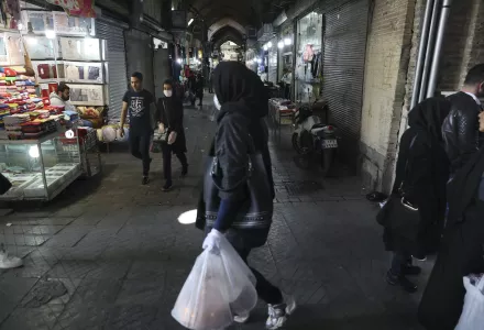 In this Tuesday, March 17, 2020, photo, shoppers walk through the mostly closed Tehran's Grand Bazaar, Iran.