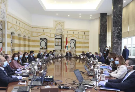 In this photo released by the Lebanese Government, President Michel Aoun, center, and government ministers wear masks to help protect themselves from the coronavirus, while attending a cabinet meeting at the presidential palace in Baabda, east of Beirut. 