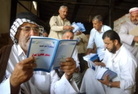 An Iraqi man looks at a copy of the country's new constitution at a distribution center in Najaf, Iraq.