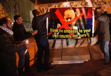 Palestinians hold a poster showing President Donald Trump during a protest in the west bank city of Bethlehem. Friday, Jan. 20, 2017.