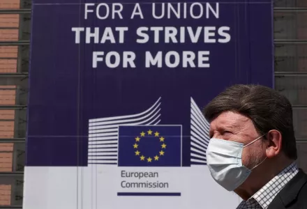 A man wearing a face mask walks past the European Commission headquarters in Brussels, Belgium on April 9, 2020