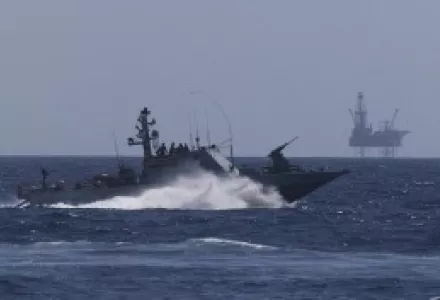 An Israeli Navy vessel passes by the Tamar drilling natural gas production platform during a squadron exercise off the coast of Israel in the Mediterranean Sea.