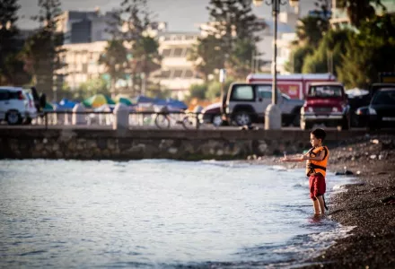 A boy stands on the shore of a beach in Kos where he is staying together with his family. //Stephen Ryan/IFRC