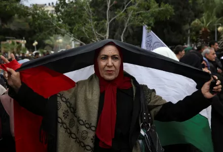 A women holds a Palestinian flag during a protest at the Unknown Soldier Square, in Gaza City, Wednesday, Dec. 6, 2017. 