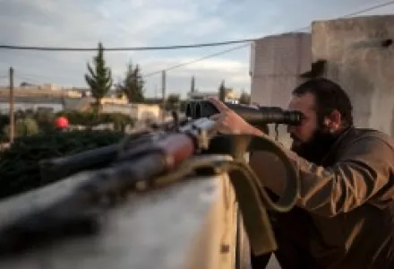 A Syrian opposition fighter watches over as heavy fighting breaks out in in the Idlib province countryside.