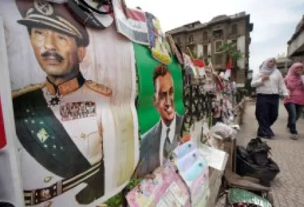 Egyptian pass by posters showing late Presidents Anwar Sadat, left, and Gamal Abdel Nasser, on a Cairo street.