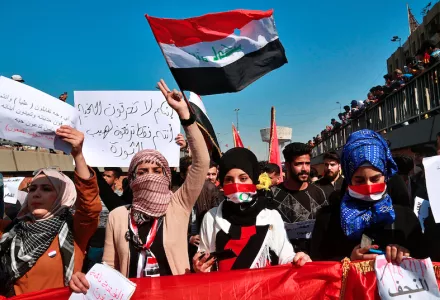 Students and other demonstrators hold national flags during a protest to condemn a militia attack on Najaf protesters in Tahrir Square, Baghdad, Iraq, Thursday, Feb. 6, 2020.