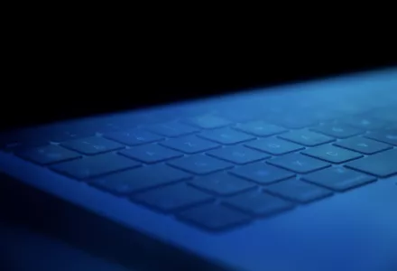A computer keyboard in blue lighting